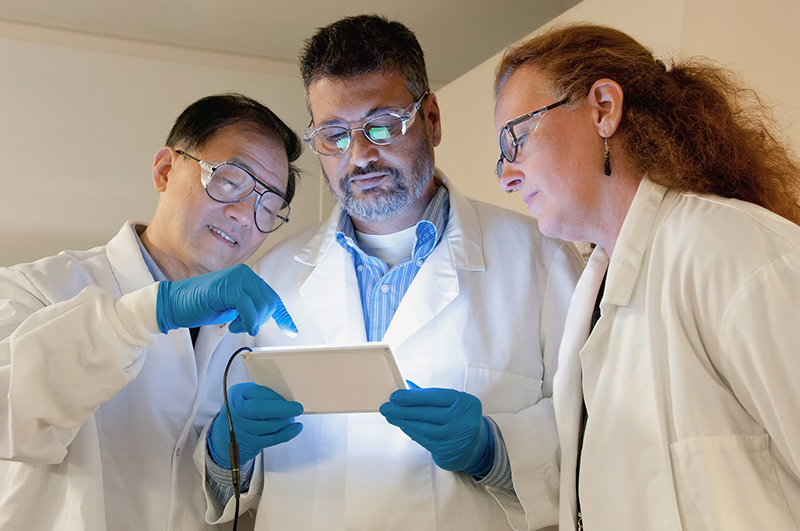 Scientists looking at a tablet.